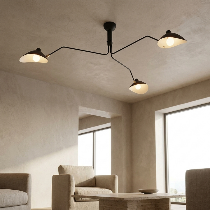 Multi-Arm Spider Ceiling Light in Black (3-Head) installed in a contemporary living room, viewed from below showing the sculptural arm silhouette against a plastered ceiling.