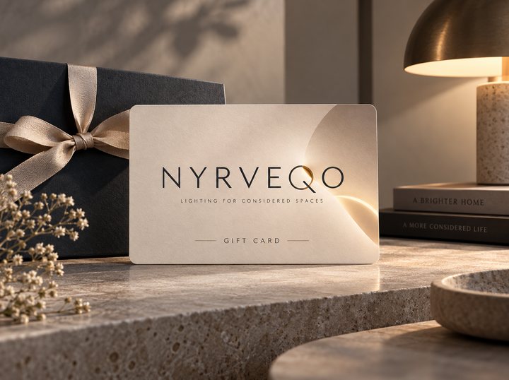 NYRVEQO Gift Card resting on a marble surface beside a warm brass table lamp in a contemporary living room